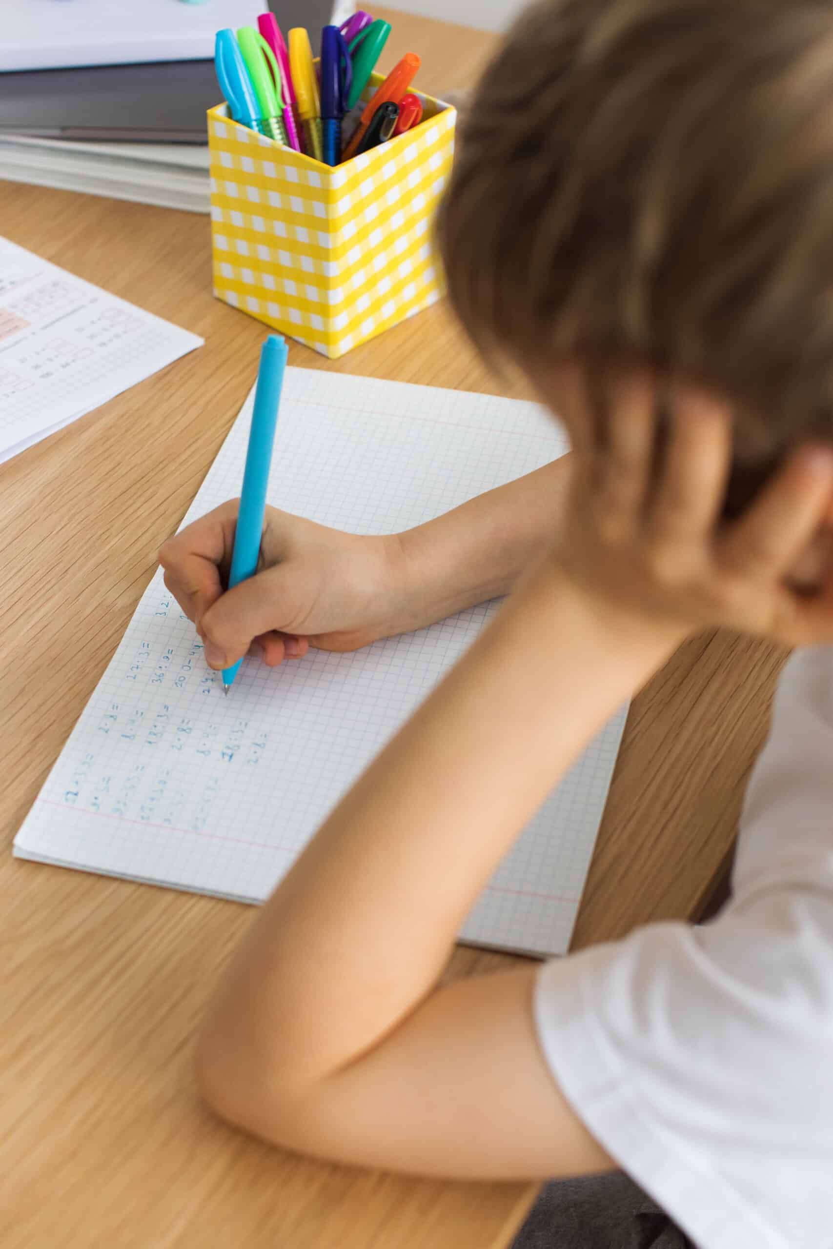 Enfant en train de réfléchir sur un devoir d'école