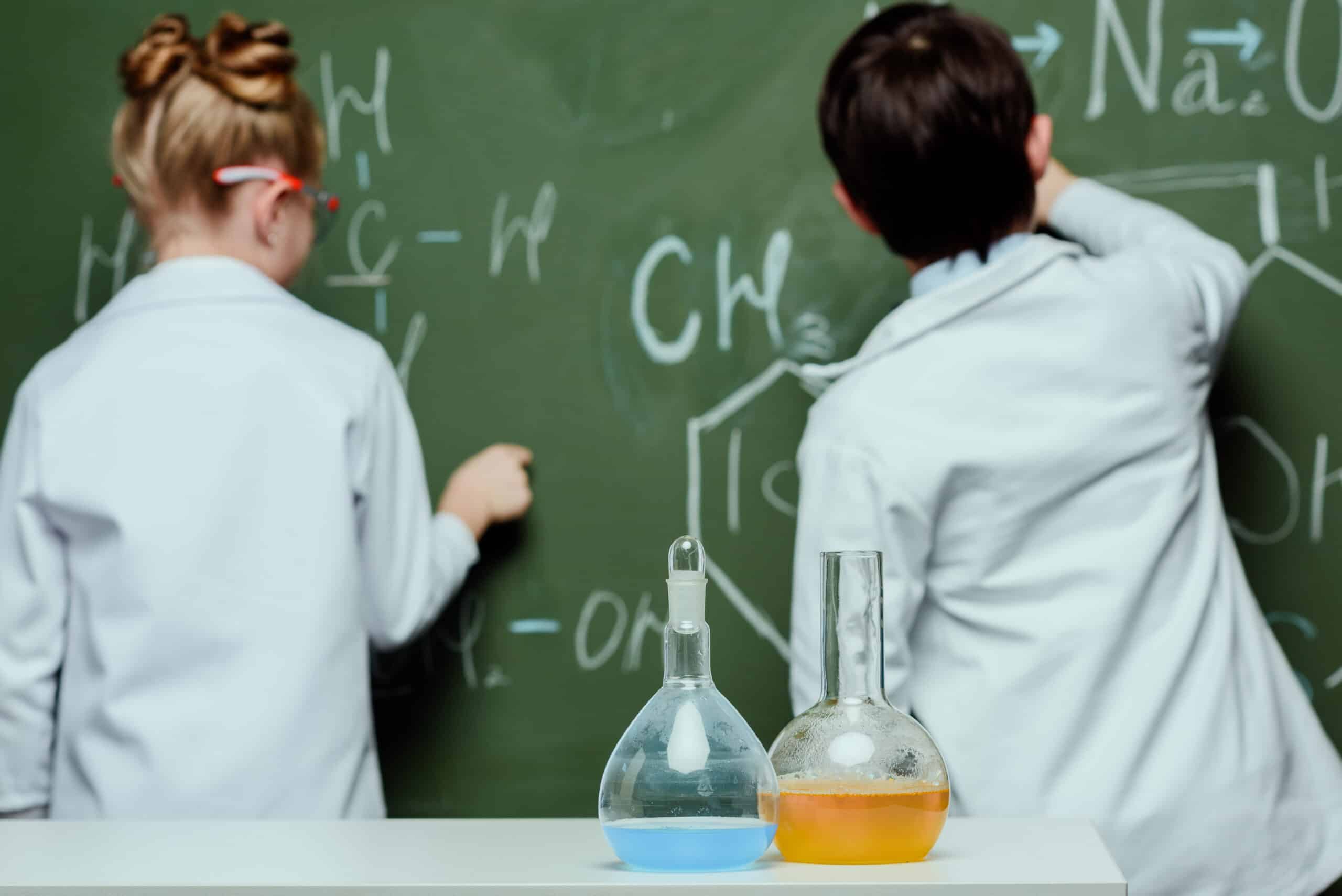 Enfant en blouse en train de résoudre une formule mathématique